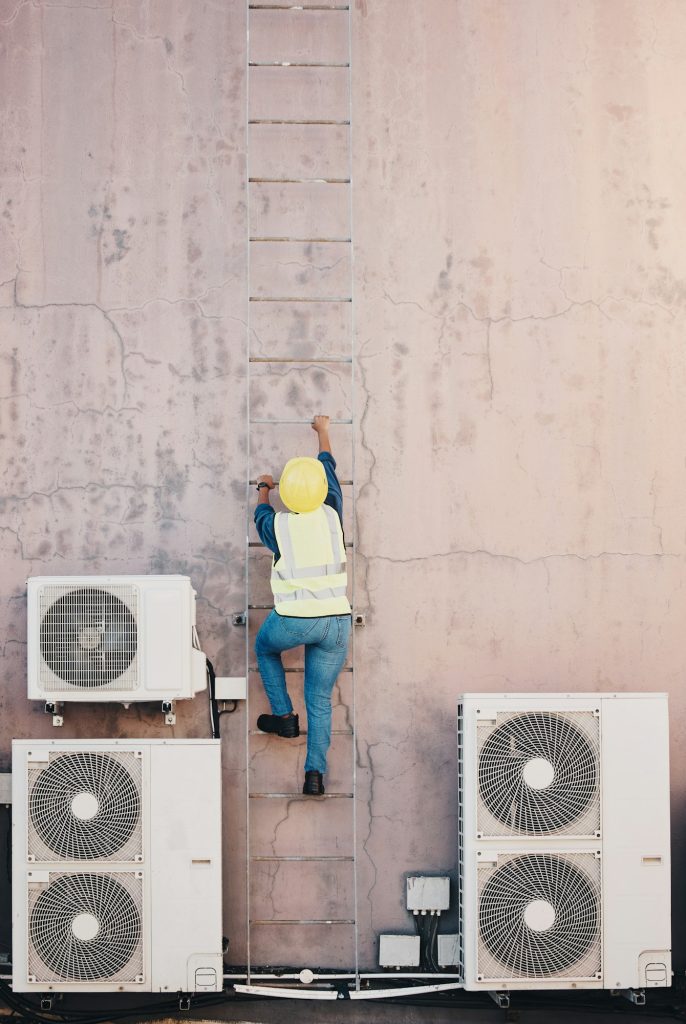 Technician, ladder and outdoor wall for air conditioner maintenance, construction or site inspectio